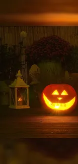 Halloween pumpkin with glowing face next to lantern and flowers.