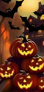 Halloween wallpaper with pumpkins, bats, and a haunted house in the background.