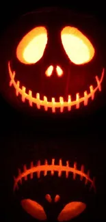 Glowing jack-o'-lantern with reflection on dark background.