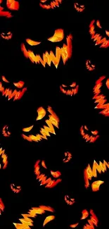 Spooky pumpkin faces on a Halloween wallpaper with dark background.