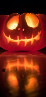 Glowing carved pumpkin against dark background, perfect for Halloween wallpaper.