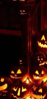 Halloween wallpaper with glowing pumpkins on stairs.