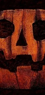 Spooky carved pumpkin face on dark background.