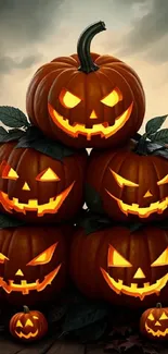 Stack of glowing Halloween pumpkins with spooky carved faces.