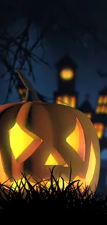 Glowing jack-o'-lantern with haunted house in dark background.