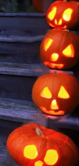 Glowing carved pumpkins on wooden stairs for Halloween.