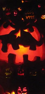 Glowing jack-o'-lantern wallpaper with spooky pumpkins for Halloween.