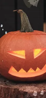 Halloween-themed pumpkin with glowing face on a dark background.