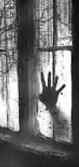 Black-and-white wallpaper with a ghostly hand on a window.