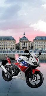 Sport bike in front of a historic chateau with a reflective city backdrop.