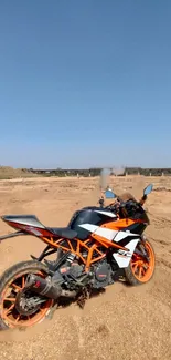 Sport bike on desert terrain under clear blue sky.