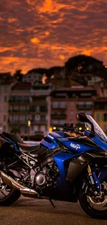 Blue sportbike with city and sunset scene on wallpaper.