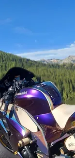 Colorful sportbike on a mountain road under clear blue sky.