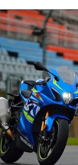 A blue sportbike on a vibrant racing track, perfect for mobile wallpaper.