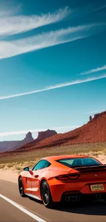 Orange sportscar driving through a scenic desert landscape under a vibrant sky.