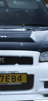 Front view of a sporty black and white car with detailed headlights.