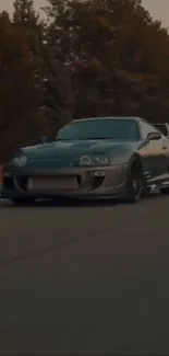 A sleek sports car speeding down a tree-lined road at dusk.