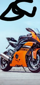 Bright orange sports motorcycle against blue sky.