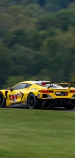 Yellow racing car on track with green backdrop wallpaper.