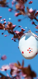 Springtime wallpaper with a painted Easter egg and blossoms against blue sky.