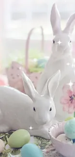 White ceramic bunnies with pastel eggs and flowers in spring setting.