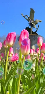 Pink tulips with bubbles under a blue sky and garden sculpture.