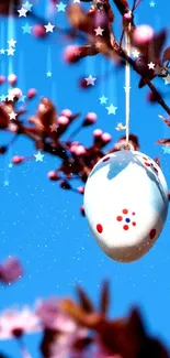 Easter egg hanging on cherry blossom branch with blue sky.