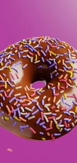 Colorful chocolate donut with sprinkles on pink background.