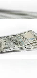 Stack of Indian rupee notes on bright white background.