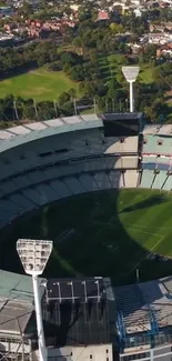 Aerial view of a large stadium surrounded by greenery.