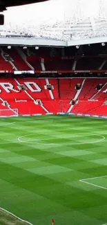 Vibrant stadium field with lush grass and iconic red seats, ideal for mobile wallpaper.