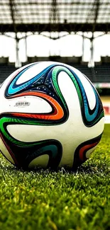 Soccer ball on green stadium field wallpaper.