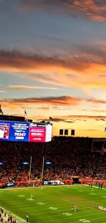 Vibrant sunset over football stadium filled with fans.