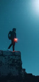 Person stands on cliff under starry night sky.