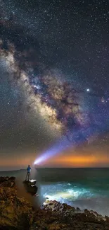 Man stargazing by ocean with Milky Way above.