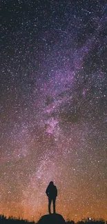 Silhouette of person under a starry night sky, showcasing cosmic beauty.