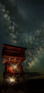 Wooden tower silhouetted against the Milky Way in a stunning night sky.