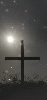 Silhouette of a cross against a starry night sky.