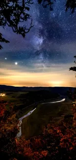 Starlit night sky with river and autumn foliage.