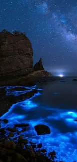 Bioluminescent waves under a starry night sky by the ocean.