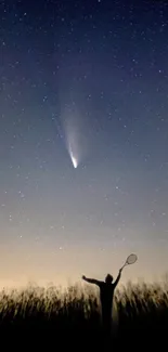 Silhouette against a starlit sky with comet.