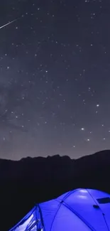 Starry night sky with glowing tent at campsite.