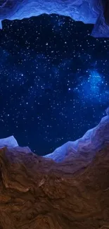 A breathtaking view of a starlit sky through a rocky cave opening.