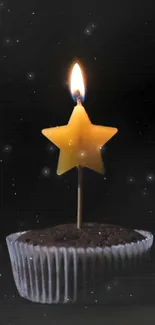 Star-shaped candle in cupcake under night sky.