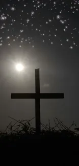 Silhouette of a cross under a starry night sky with a sun flare.