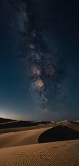 Starry night over a serene desert landscape with rolling sand dunes and galaxy.