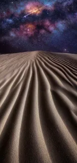 A starry night over desert sand dunes with a vibrant galaxy above.