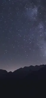 Starry night sky with mountains silhouetted below.