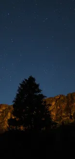 Night sky with stars and mountain silhouette wallpaper.