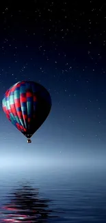 Hot air balloon over starry night sea reflection.